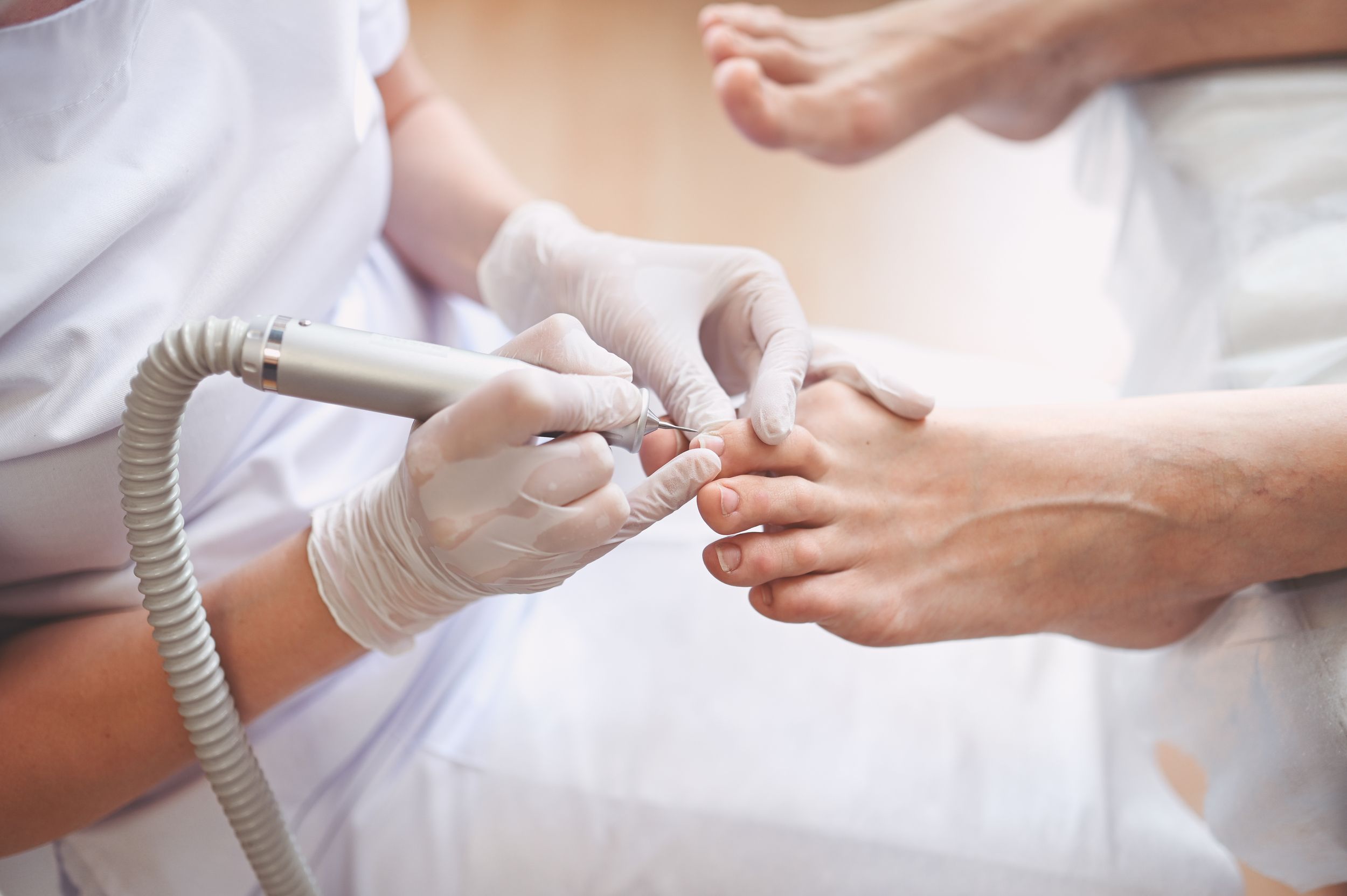 Fußpflegerin behandelt Zehennägel